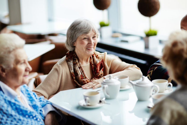 A group of senior friends having a conversation over tea.