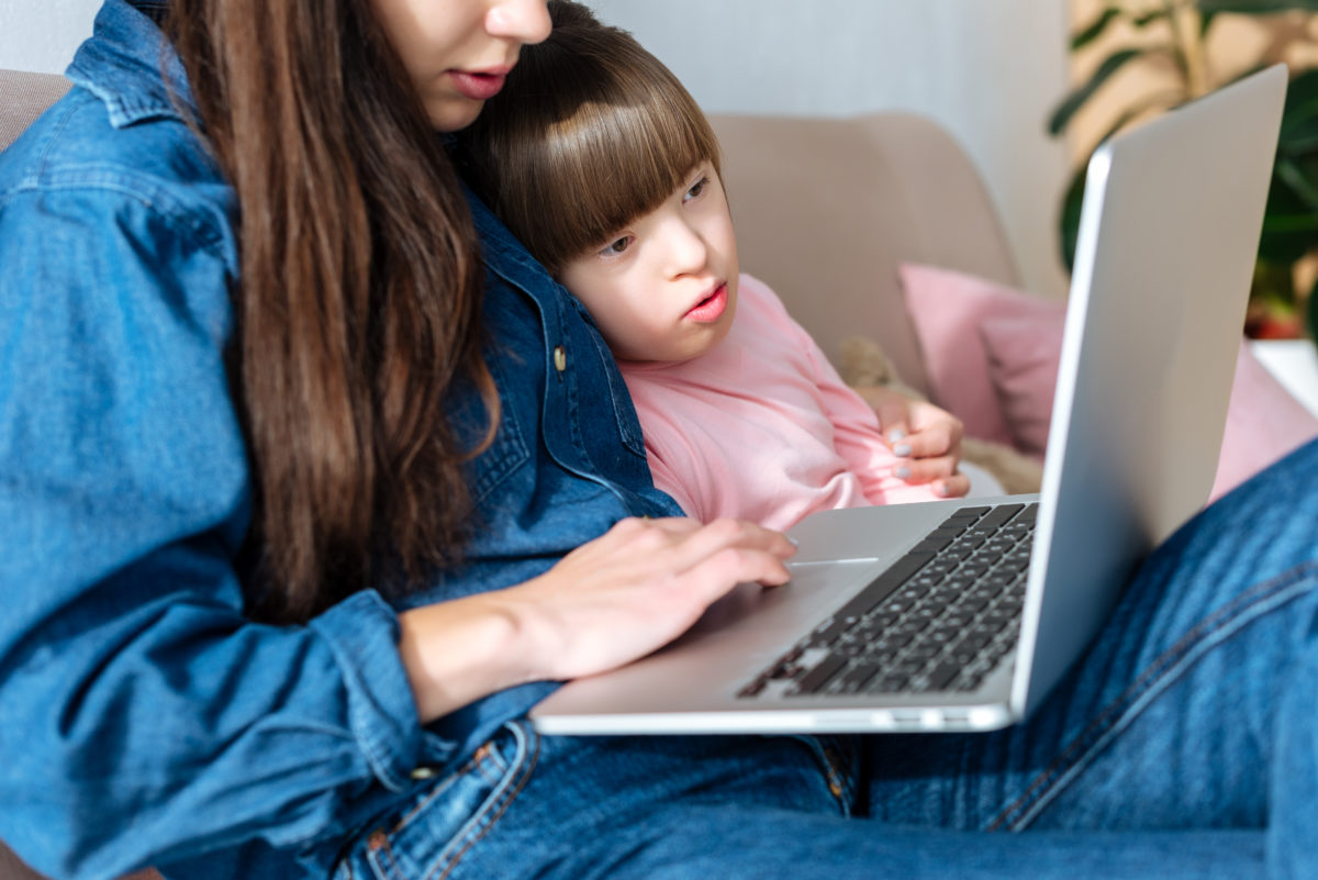 Mother and daughter with down syndrome looking at laptop screen