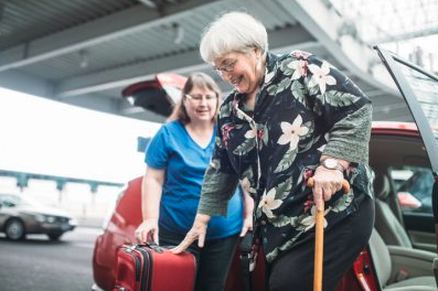 An older woman at the airport receives assistance from her support worker.