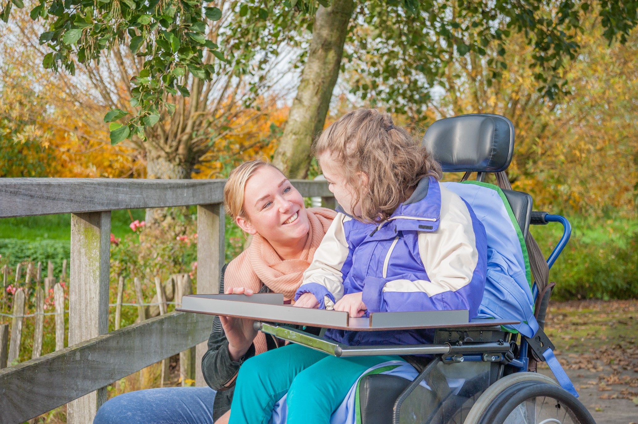 Young woman living with disability smiling with support worker