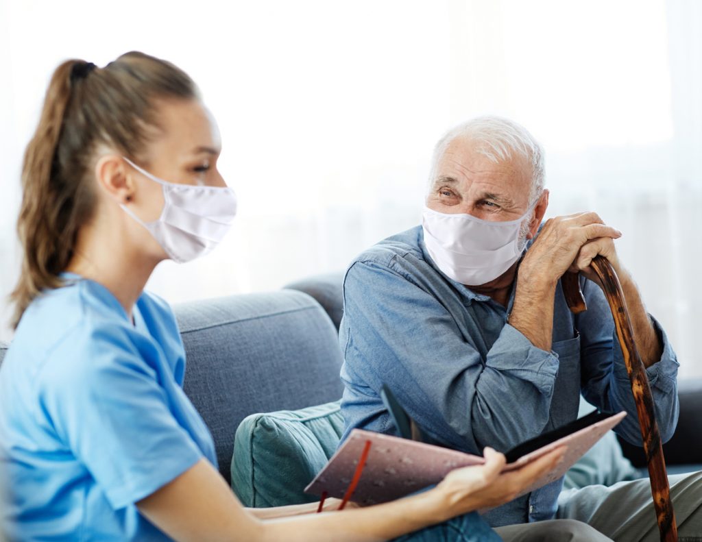 Caregiver, elderly man in masks, browse album