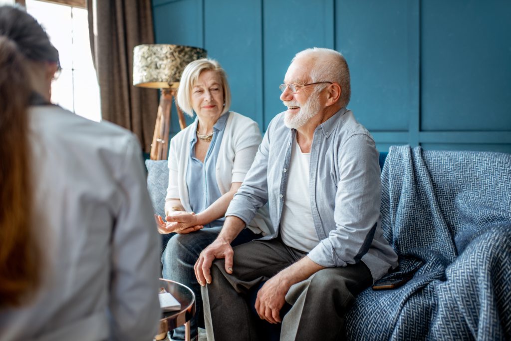 An older couple sitting with a doctor for a medical consultation.