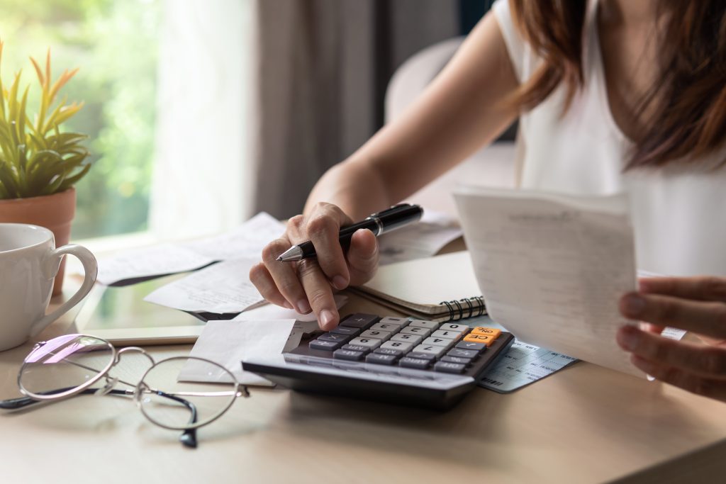Woman managing costs and calculating budget at home