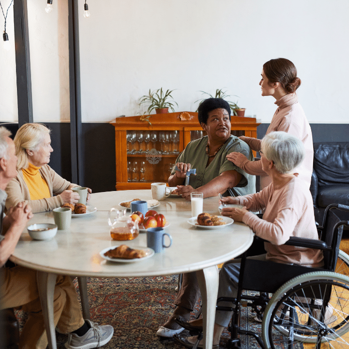 Diverse group of senior people enjoying breakfast at residential home