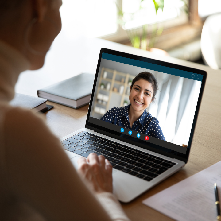 Woman sitting at home interviewing a support worker on a video call.