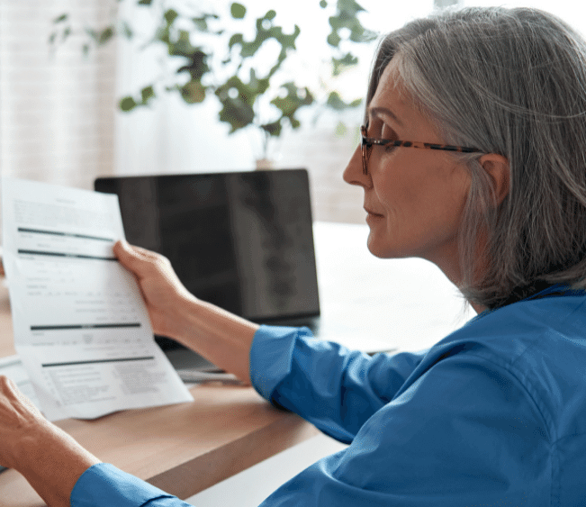 An older woman looking at a document.