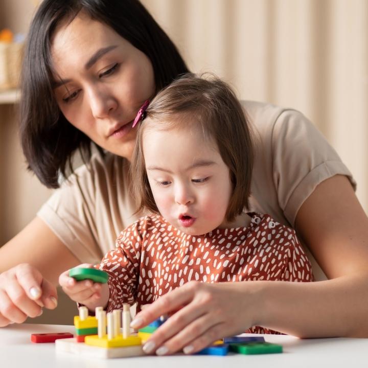 Support worker and a child playing with blocks.