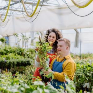 A young man with Down syndrome and his support worker gardening together.