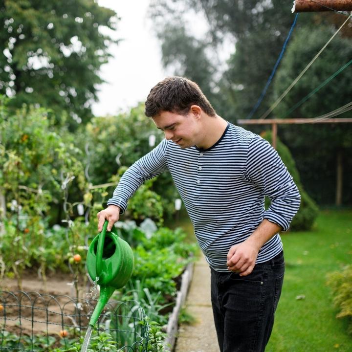 A young man with Down syndrome gardening.
