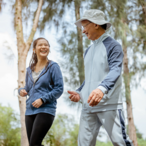An older man and his support worker walking outdoors.