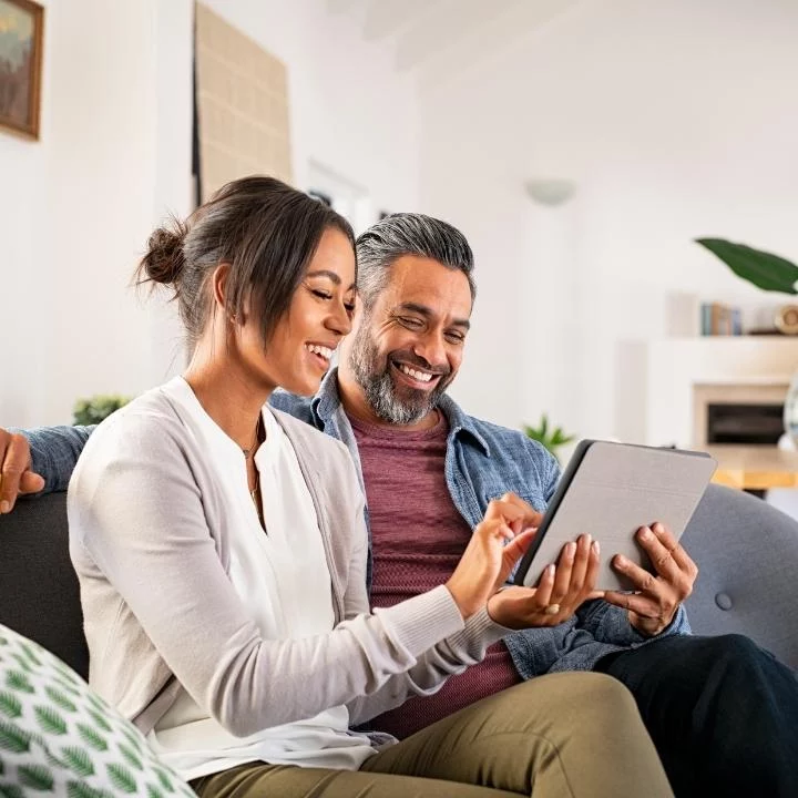 woman and man using tablet device in home environment