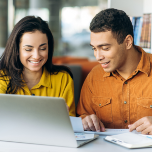 Young man and woman looking at a laptop together.