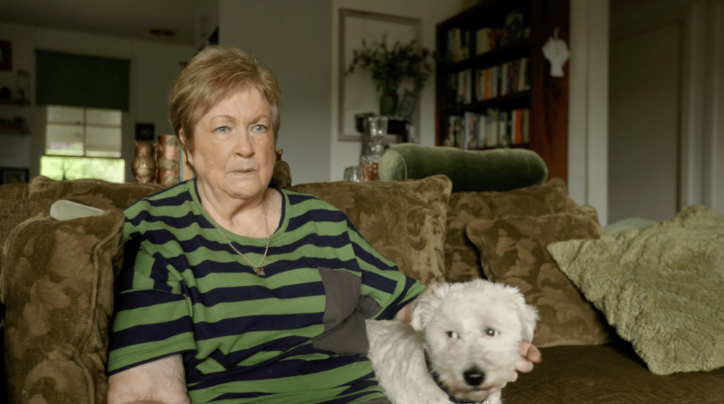 Carol sitting on the couch with her dog