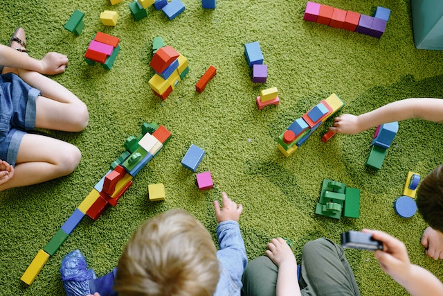 overhead shot of children playing with colourful building blocks