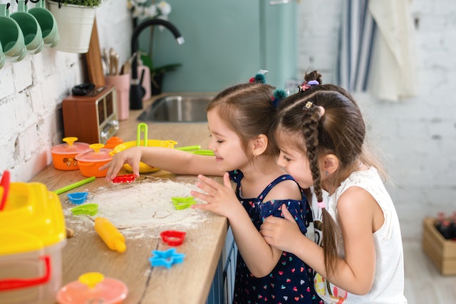 two girls excitedly playing with playdough 
