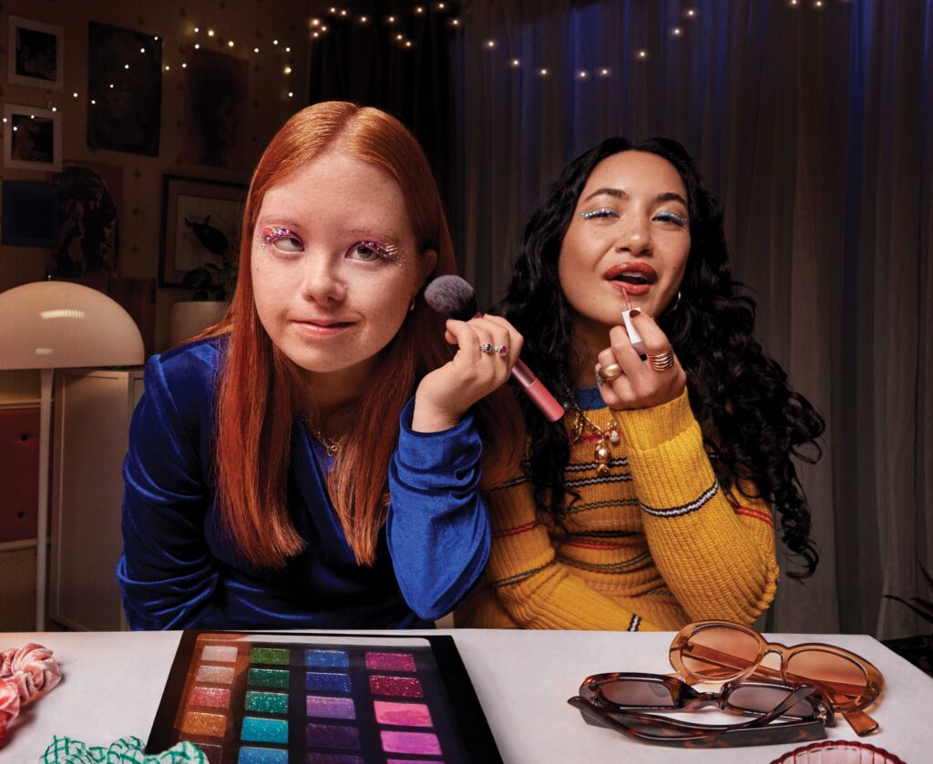 Lizzy and Tia putting on makeup together.