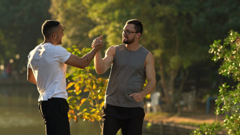 Fit men greeting each other outdoors