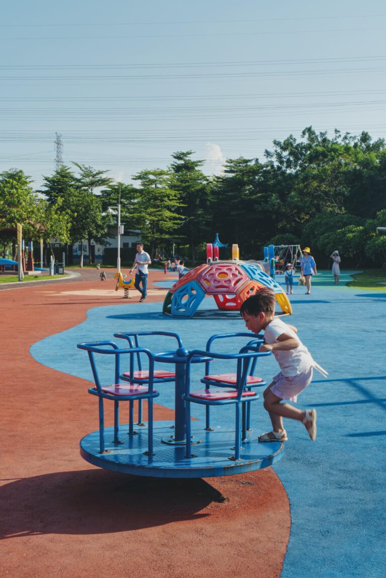 child playing on a merry go round at a playground