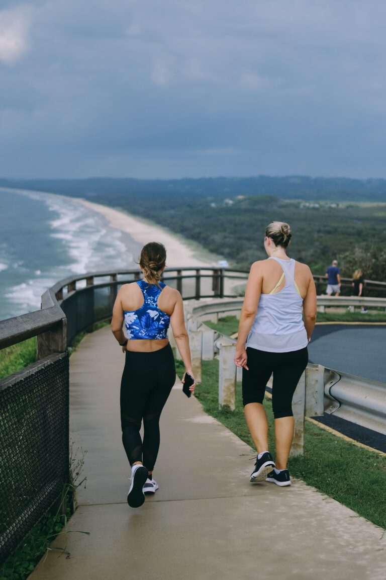 Two women walking along a beach path