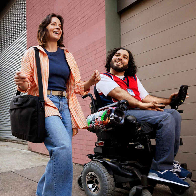In an wheelchair, on their way to work with support worker.