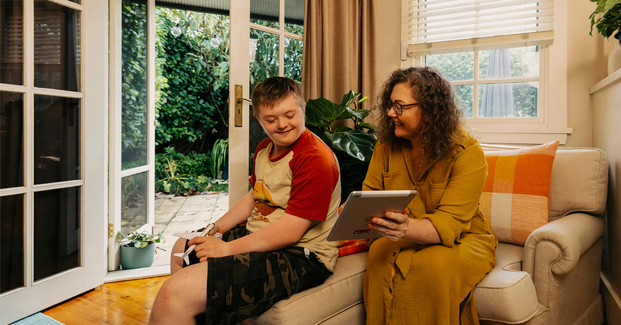 Mum shows son with disability Mable support workers on her tablet.
