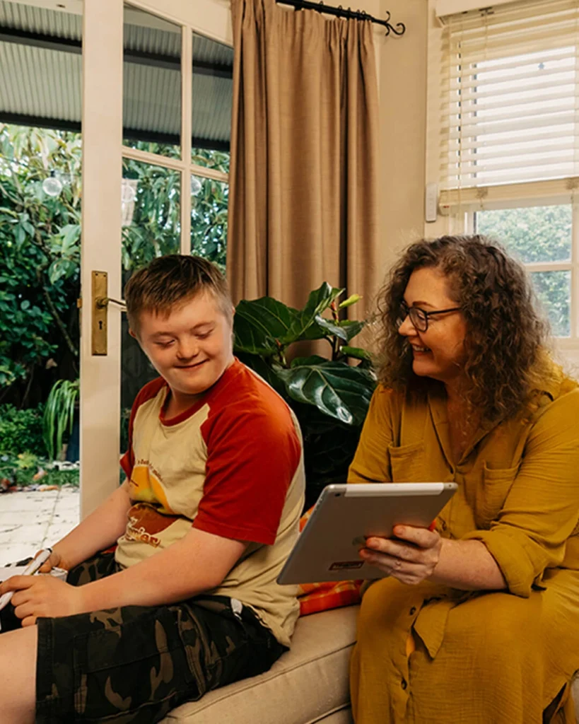 Mum shows son with disability Mable support workers on her tablet.