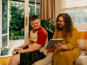 Mum shows son with disability Mable support workers on her tablet.