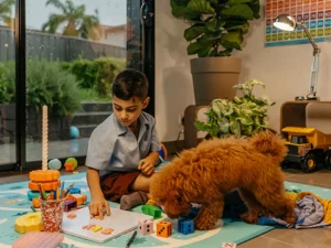 Child with language disorder concentrates as they sit on floor to play with letters of the alphabet.