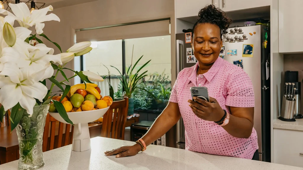 Support worker looks at mobile phone screen to manage clients on the Mable app.