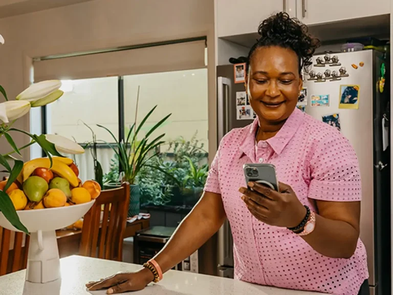 Support worker looks at mobile phone screen to manage clients on the Mable app.