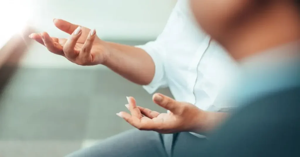 person sitting and gesturing hands