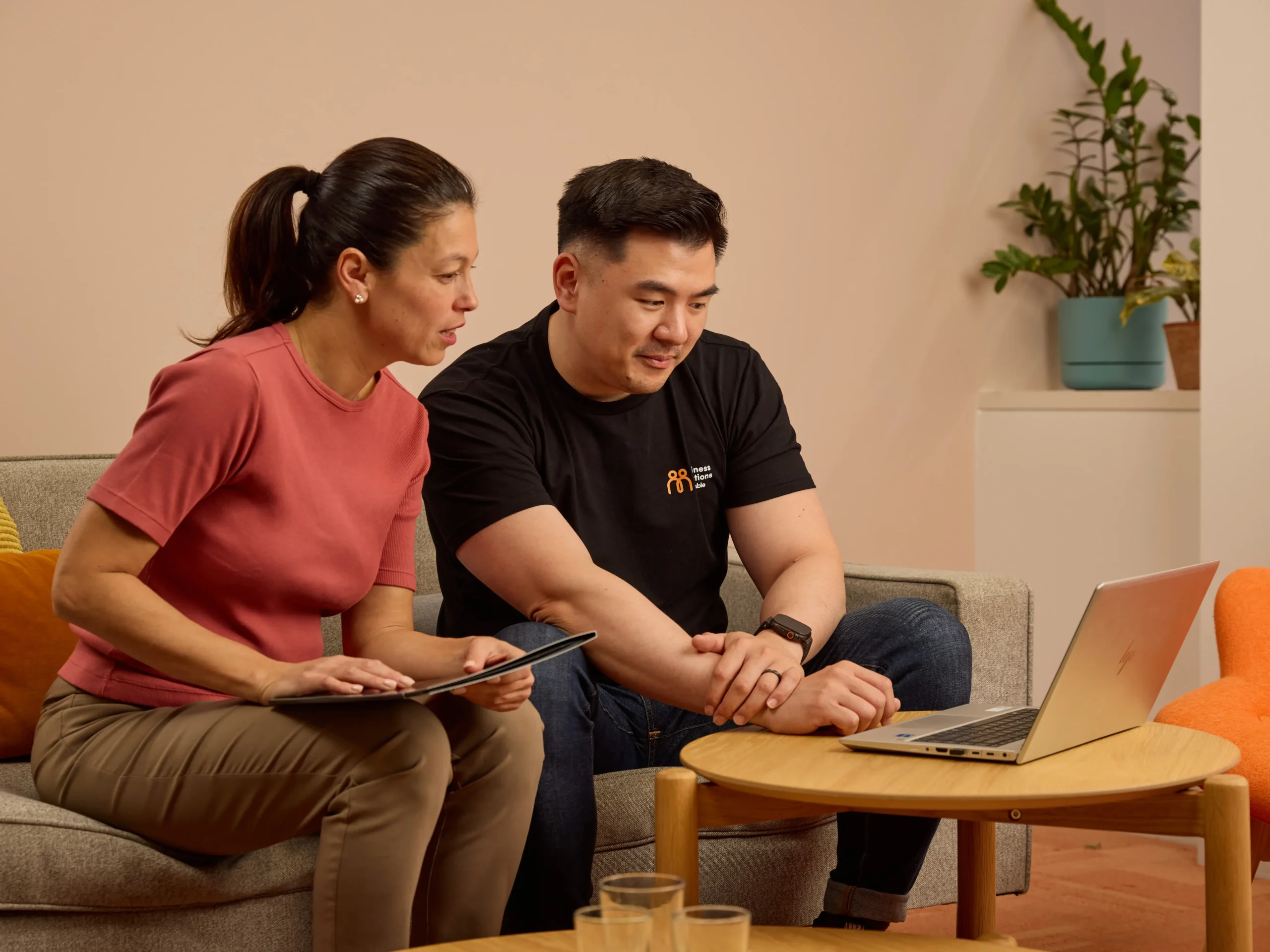 Business Solutions by Mable staff sit with a client at a laptop