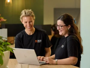 Business Solutions by Mable staff gathered around a laptop