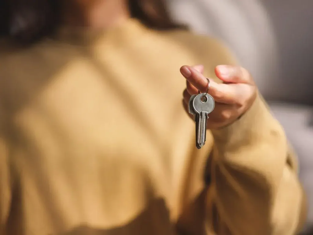 Woman holding house keys on a keyring.