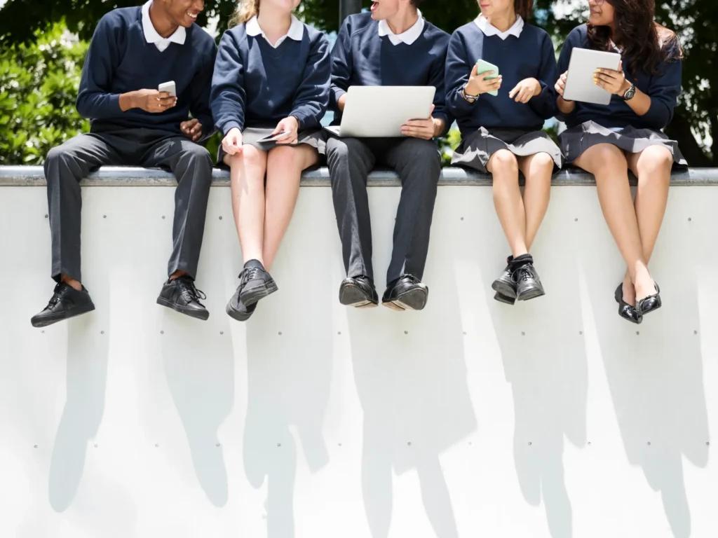 Five high school children sit together reading notes