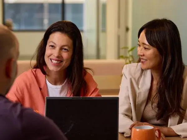 Support coordinators smiling in a meeting with a client