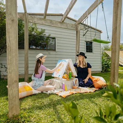 Occupational Therapist and teenager with autism paint outdoors for art therapy support session.
