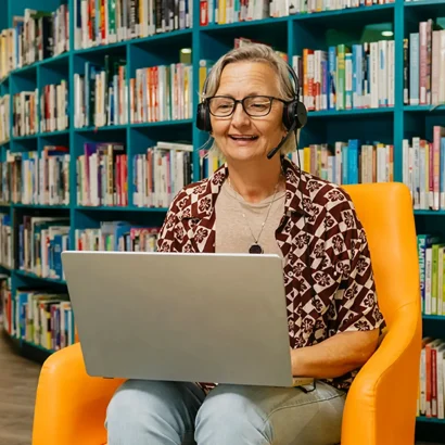 Support coordinator with laptop and headset searches support workers on Mable for their clients.