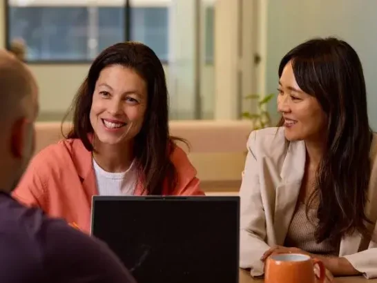 Support coordinators smiling in a meeting with a client