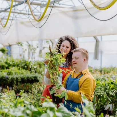 A young man with Down syndrome and his support worker gardening together.