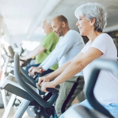 A group of older people riding exercise bikes.