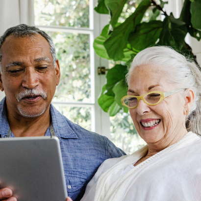 An older couple looking at a tablet together.