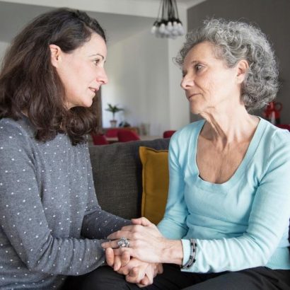 An older woman is comforted by a younger woman.