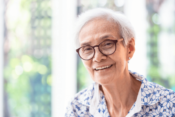 An older woman smiles at the camera.