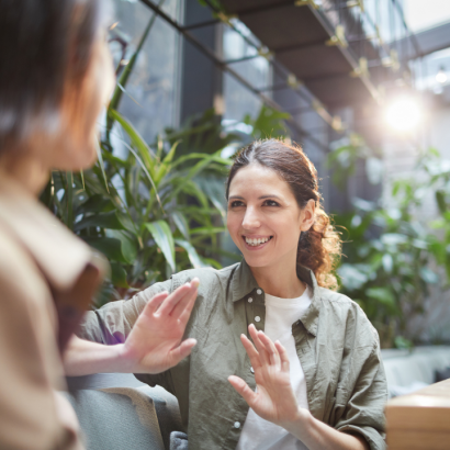 A woman talking and gesturing to a friend.