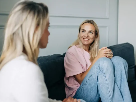 Two women speaking on the couch