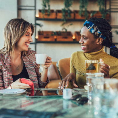 Two women drinking coffee and chatting.
