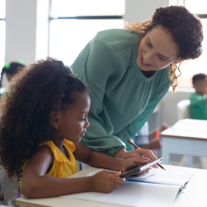 A young girl talking with her teacher.